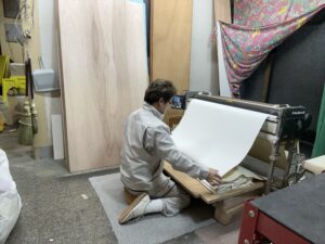 壁紙に専用の糊を塗布して現場持ち込みの準備