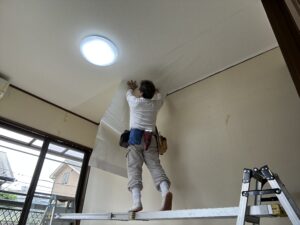 天井のクロス張替えは足場板を歩きながら貼り付けいきます。