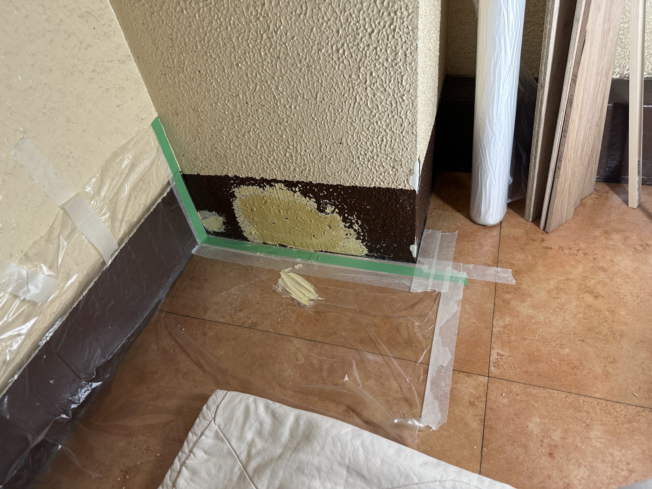 巾木にできた大きな穴を独自のパテで成形・補修し、壁色と合わせた塗装仕上げを準備している途中の様子