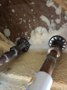 点検口から見える配管の接続部分。銅管とナットが確認できる。