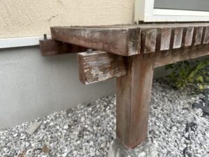 ぬれ縁の脚部と木材の傷み、塗装剥がれが目立つクローズアップ