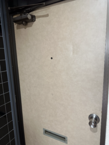 玄関ドアの施工前の状態（細かな凹みがある）