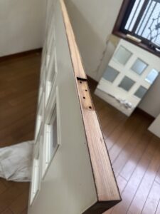 取り外したリビングドアの小口テープが剥がれた状態