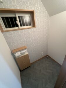 「モロッカン柄のアクセントクロスとヘリンボーン床で仕上げた、施工後のトイレ全景」