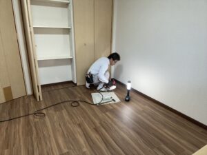 フロアタイル施工中、部屋の床材を張っている作業風景