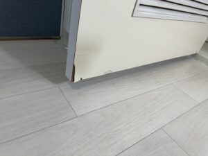 リビングドア下部のデコラ板が捲れ、欠けている施工前の状態