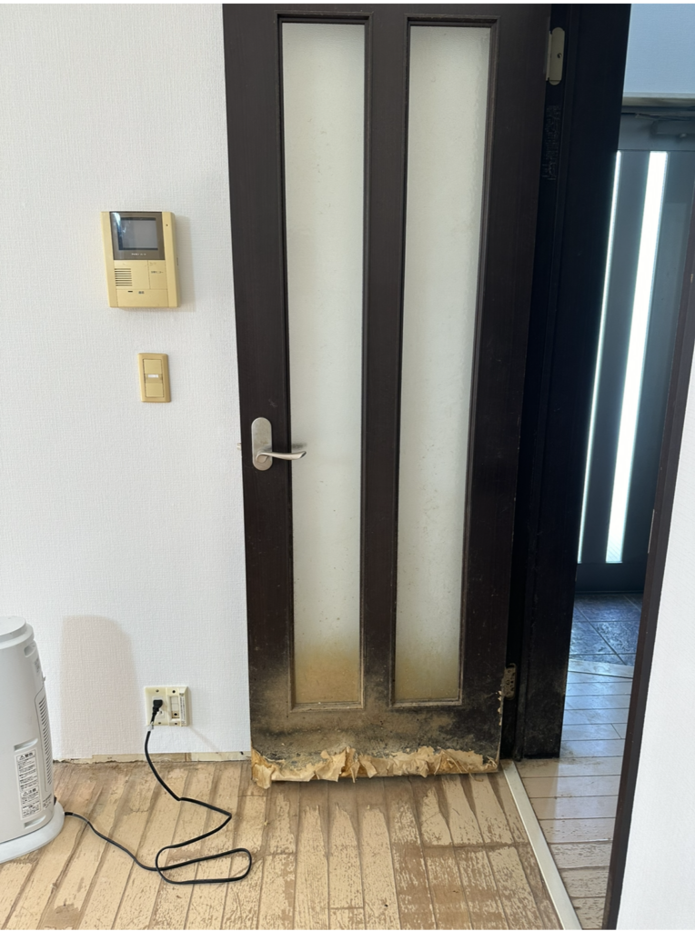 ペットの尿によって大きく傷んだリビングドアの施工前（全体）