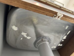 シンク裏側の腐食部を下処理・補修している様子