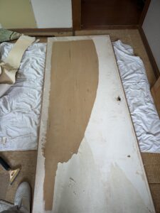 既存の襖紙を剥がし始めたドア