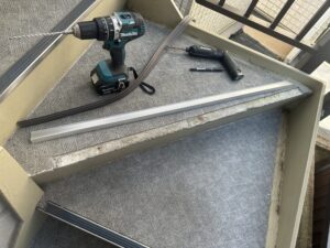 下地へアンカーを打ち込みノンスリップを固定する作業