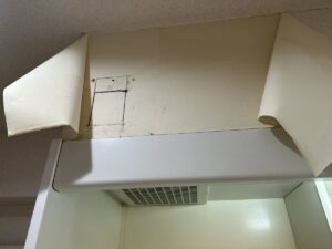 ミニキッチン上部を開口して換気扇を確認する様子